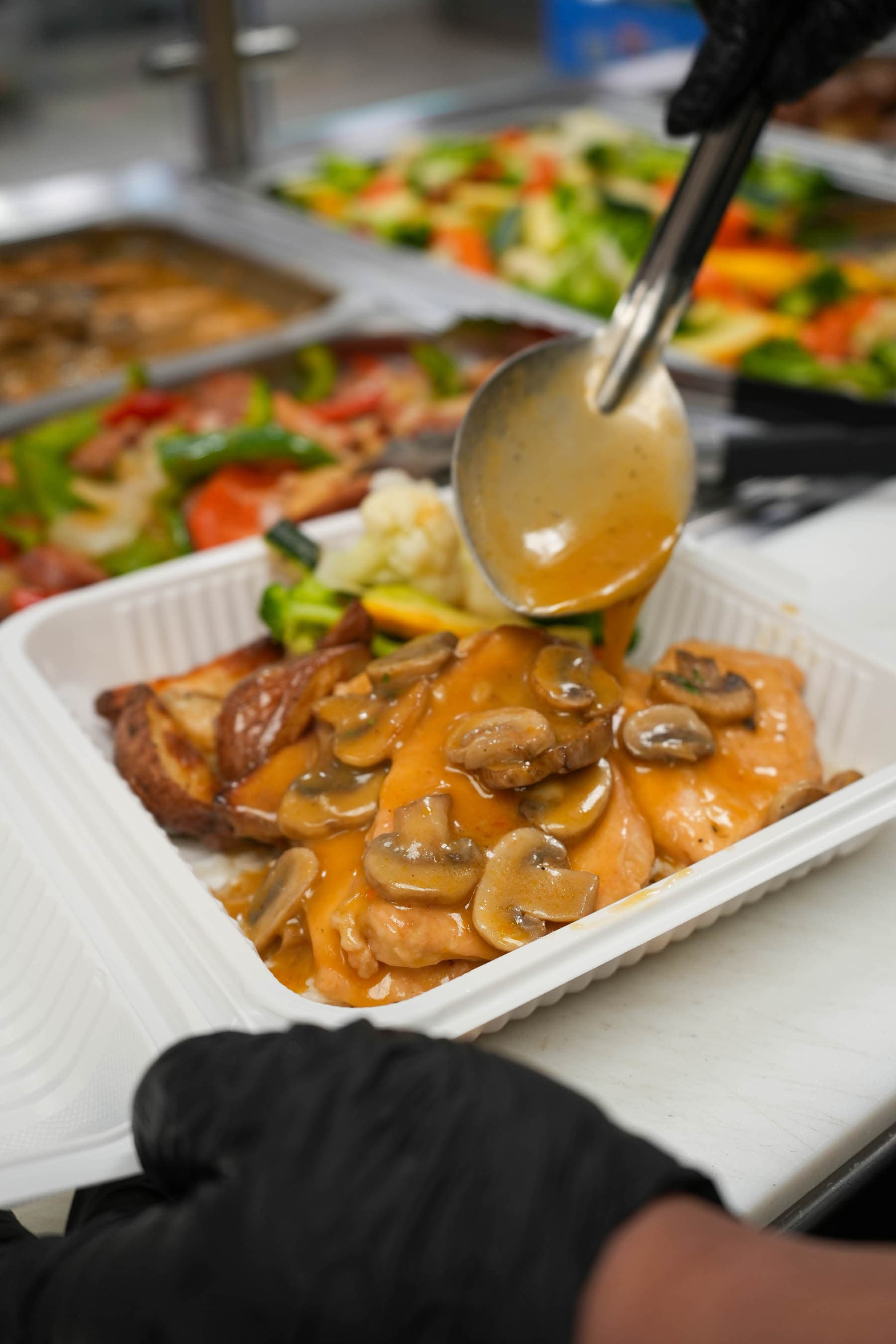 A freshly prepared hot meal being served with gravy